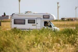 camping-car blanc et marron sur un terrain en herbe verte pendant la journée